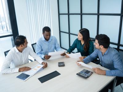 Four employees sitting at table having a business meeting
